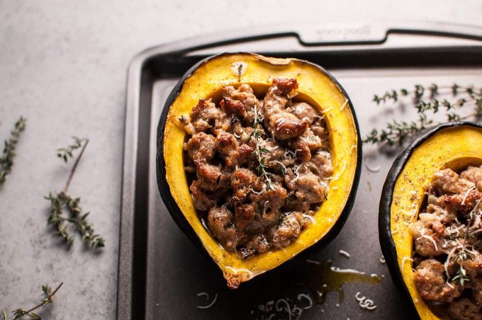 sausage stuffed acorn squash on baking sheet