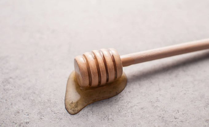 close-up of wooden honey dipper with honey