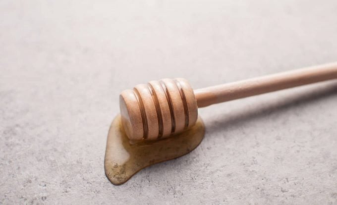 close-up of wooden honey dipper with honey