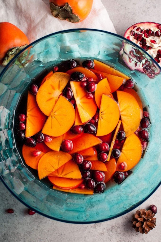 blue punch bowl with winter sangria with pomegranate and persimmon