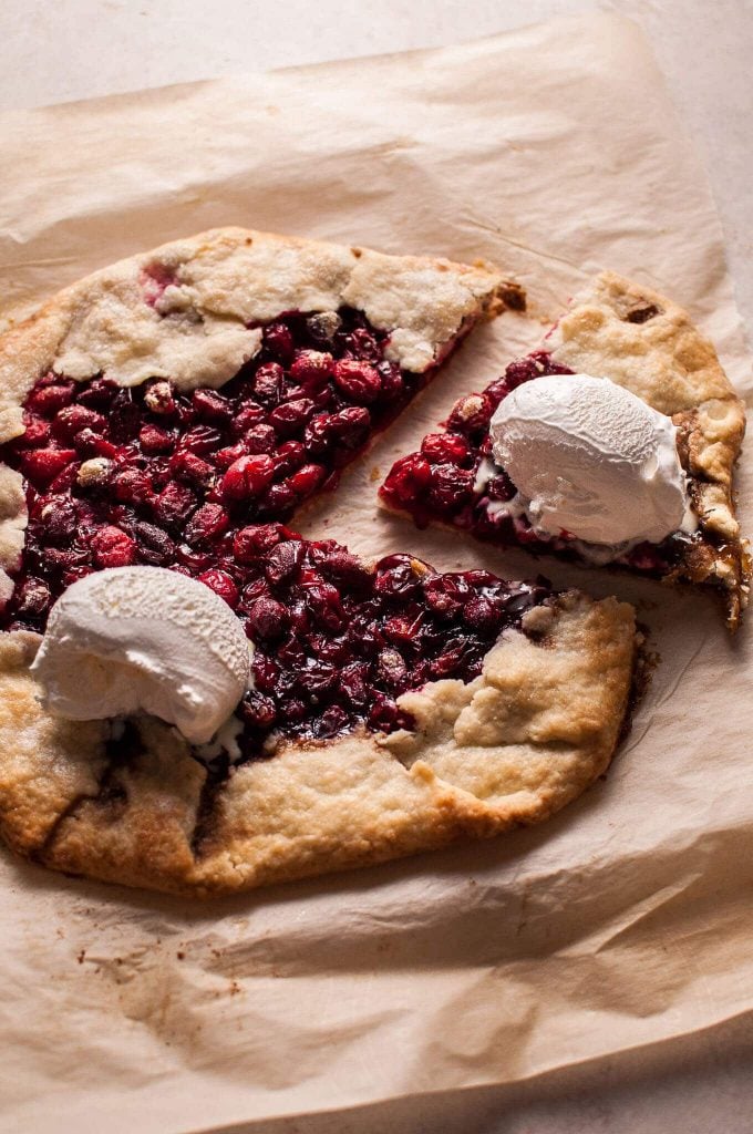 close-up of rustic cranberry galette with ice cream scoops