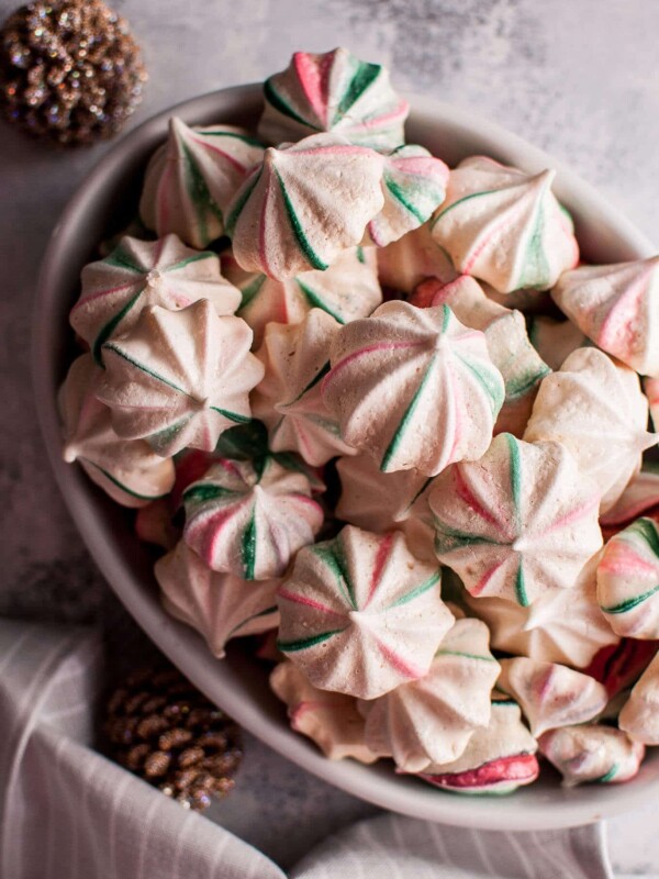 These red and green striped Christmas meringue cookies are light, melt-in-your-mouth, and fun. Flavored with vanilla and almond, and swirled with red and green, these sweet treats are extra festive.