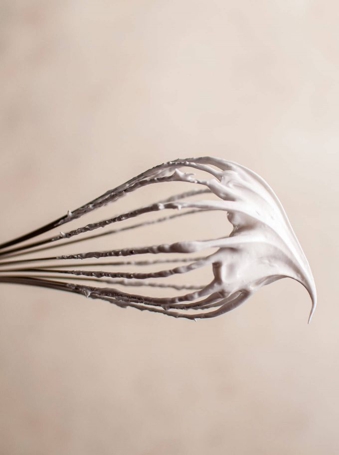 close-up of a metal whisk with meringue batter