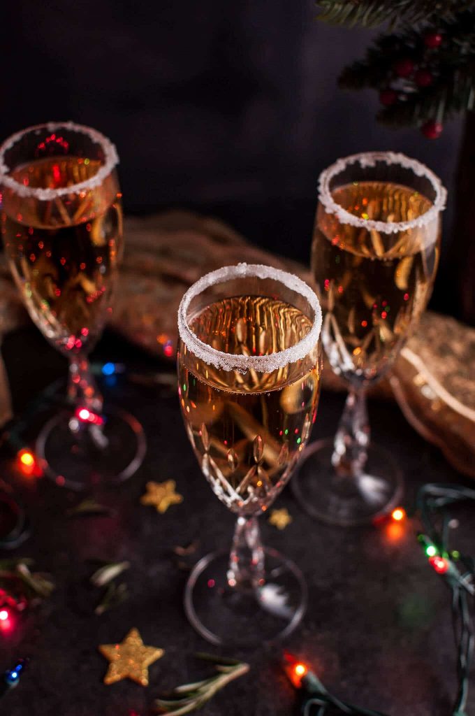 three glasses of Christmas pear champagne cocktail with Christmas lights