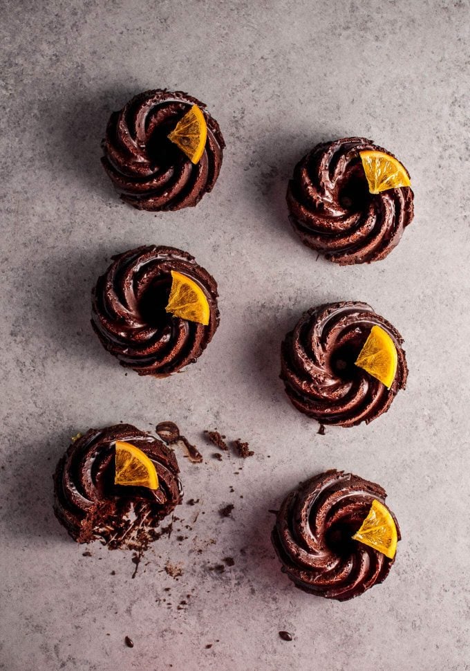 several festive mini chocolate bundt cakes with candied orange slices