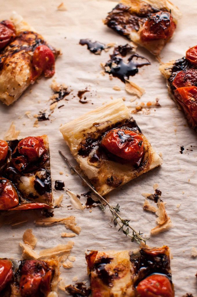 roasted tomato puff pastry appetizer slices on parchment paper