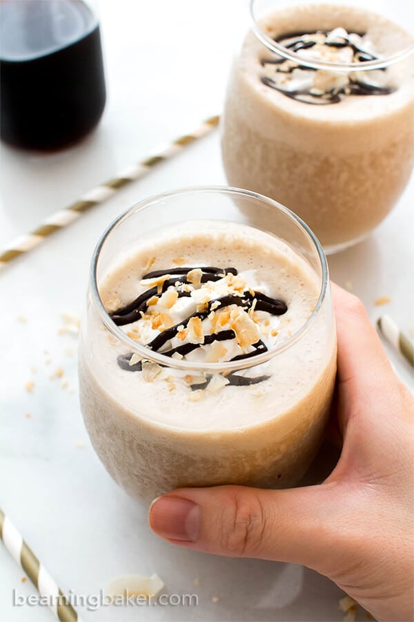 hand holding glass of coconut coffee homemade frappuccino