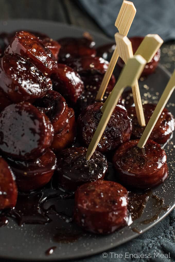 several red wine chorizo bites with toothpicks on a plate