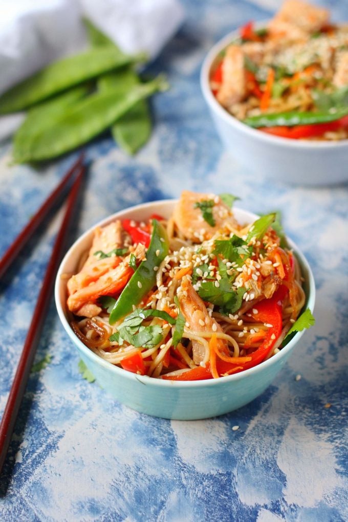 bowl of salmon soba noodles with vegetables beside chopsticks