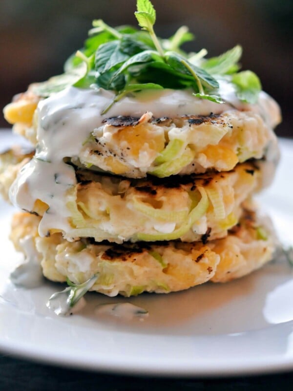 a stack of three corn leek fritters with herbed yogurt