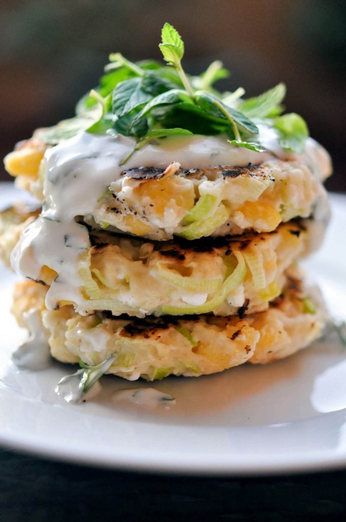 close-up of stack of three corn leek fritters with herb yogurt