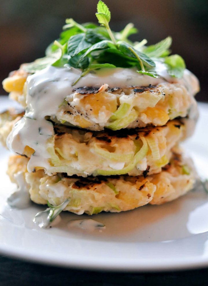 a stack of three corn leek fritters with herbed yogurt