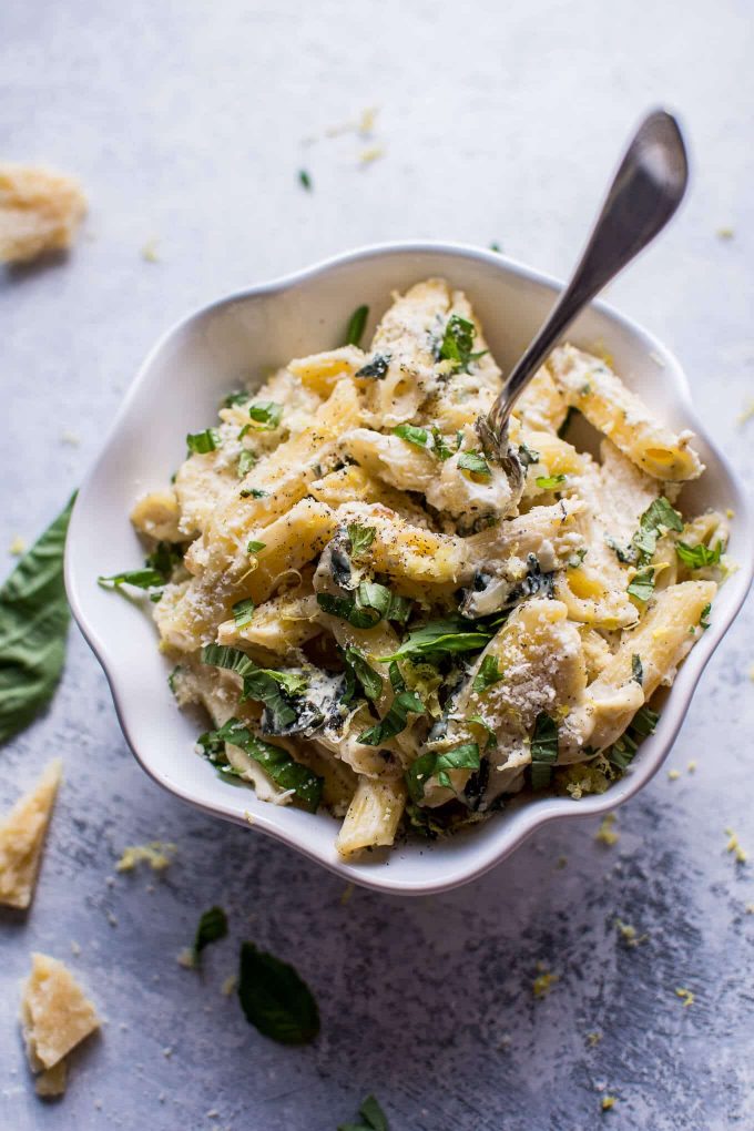 creamy lemon basil pasta in a white bowl with a fork