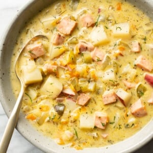 a bowl of dill pickle soup with a spoon