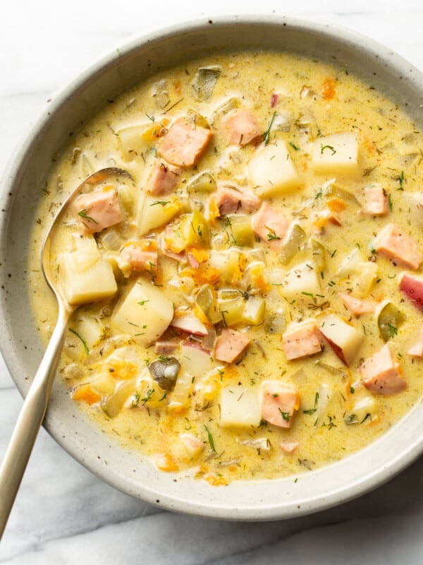 a bowl of dill pickle soup with a spoon