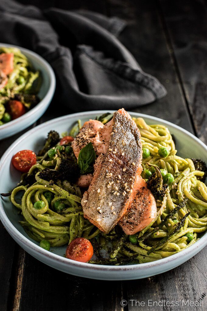 green goddess pasta bowls topped with salmon and baby tomatoes