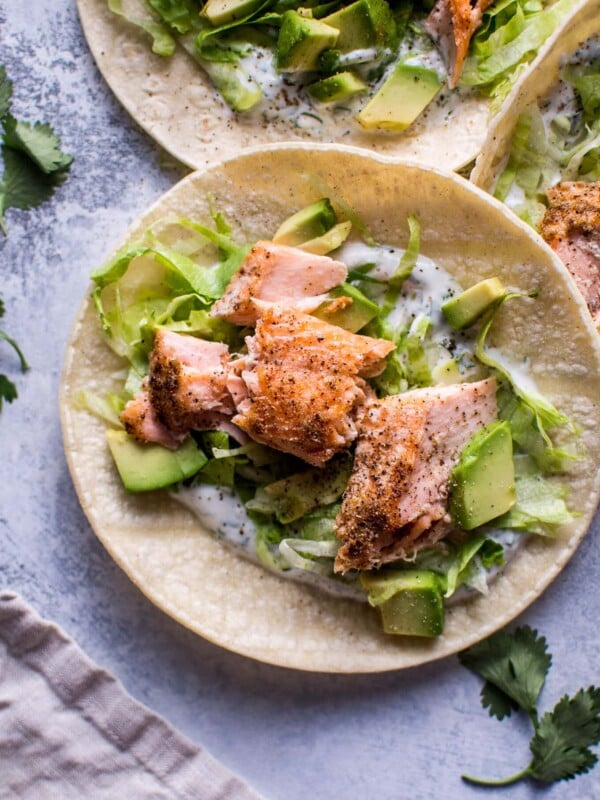 My healthy baked salmon tacos are fresh and full of flavor and ready in under 30 minutes. The cilantro lime Greek yogurt dressing tastes just as good as sour cream but contains fewer calories.