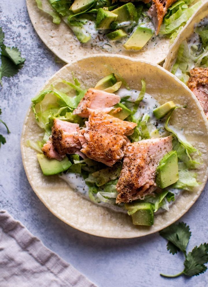 My healthy baked salmon tacos are fresh and full of flavor and ready in under 30 minutes. The cilantro lime Greek yogurt dressing tastes just as good as sour cream but contains fewer calories.
