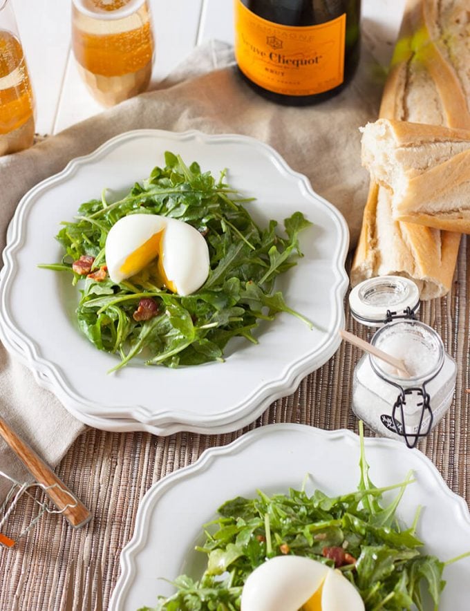 salad lyonnaise on plates with baguette and champagne