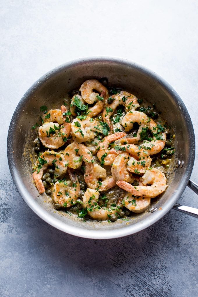 metal skillet with shrimp, lemon, butter, and capers