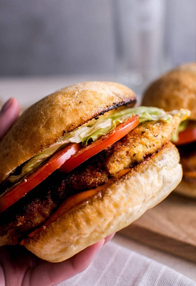 close-up of a spicy fried chicken sandwich in a hand