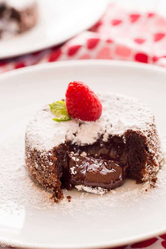 close-up of molten lava chocolate cake for two on a plate with a raspberry
