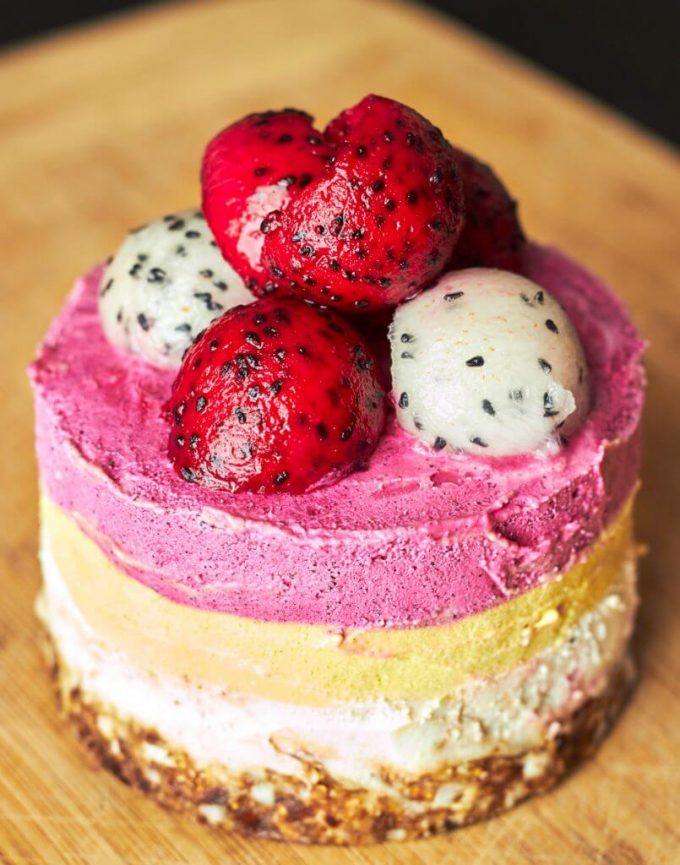 close-up of mango dragon fruit cake on a wooden board