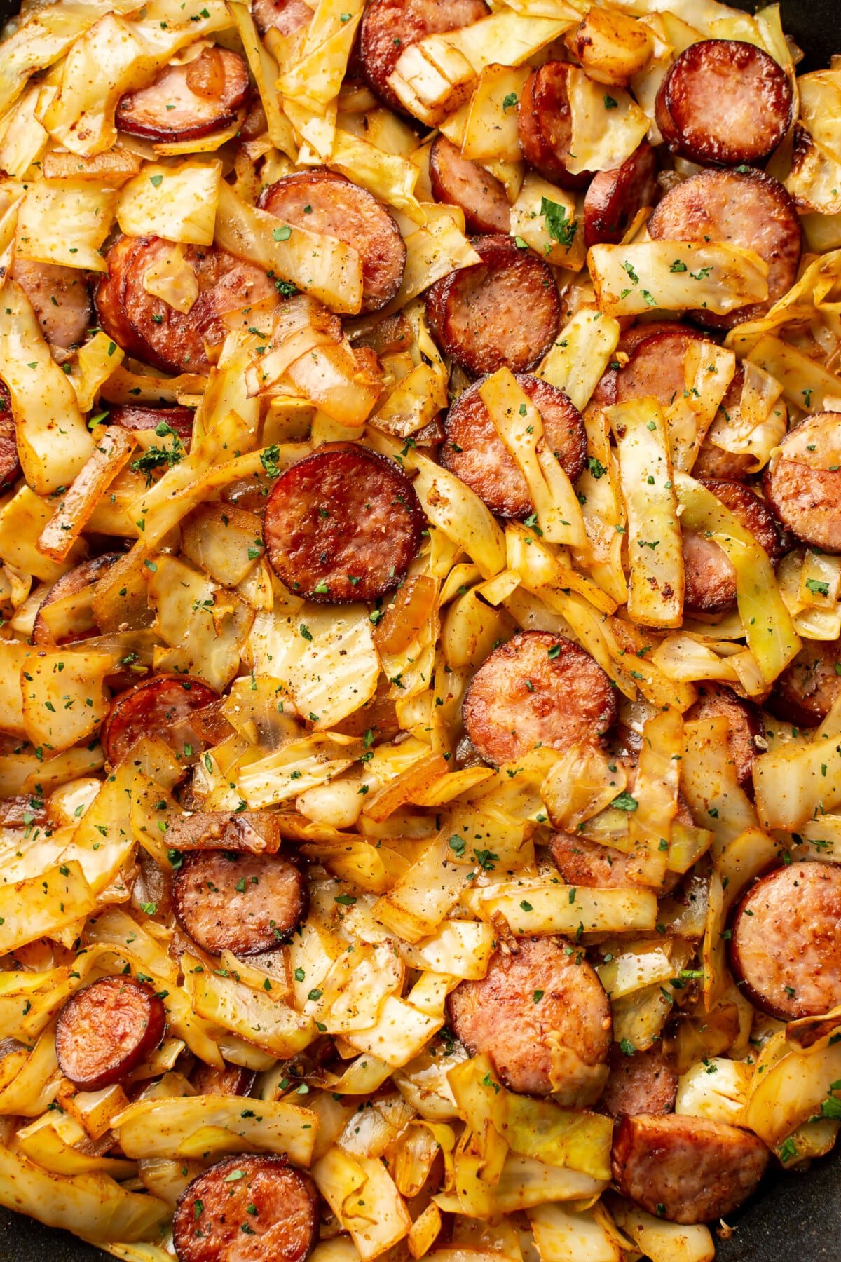 closeup of a skillet with sauteed cabbage and sausage
