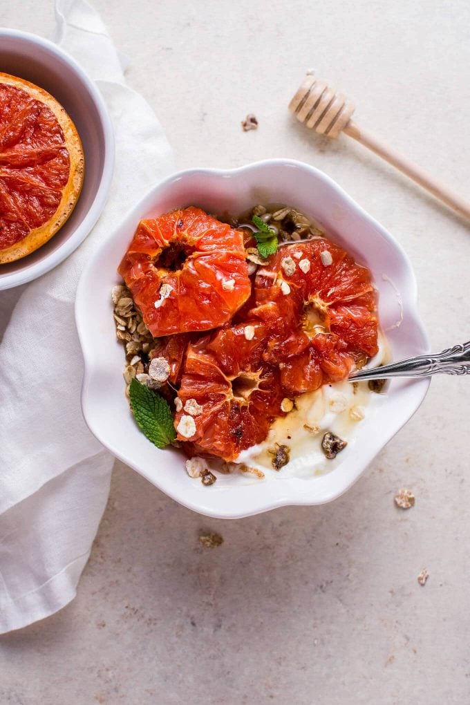 bowl of museli with broiled grapefruit slices and Greek yogurt and spoon