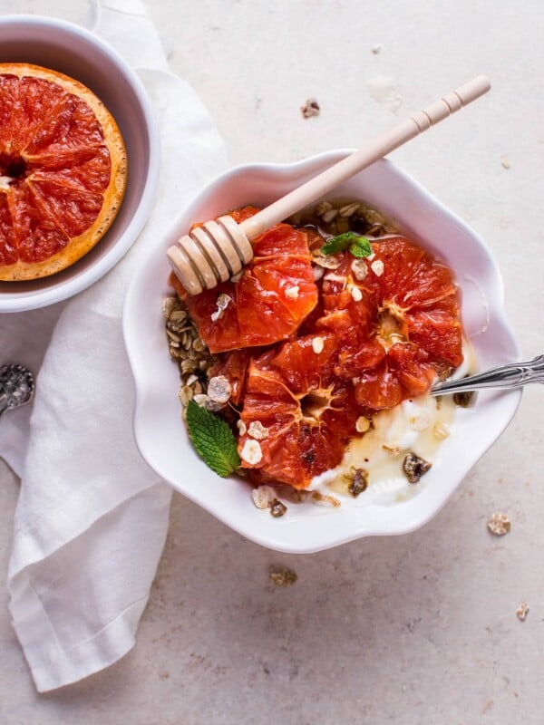 grapefruit brulee breakfast bowl with mint garnish and honey dipper on top