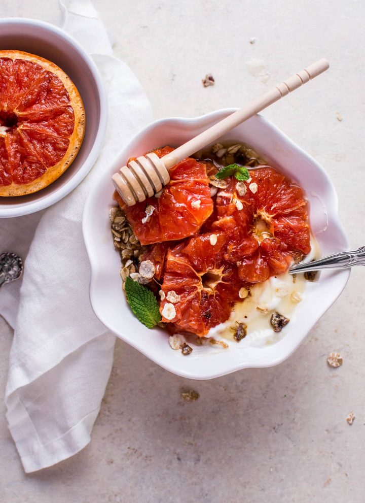 grapefruit brulee breakfast bowl with mint garnish and honey dipper on top