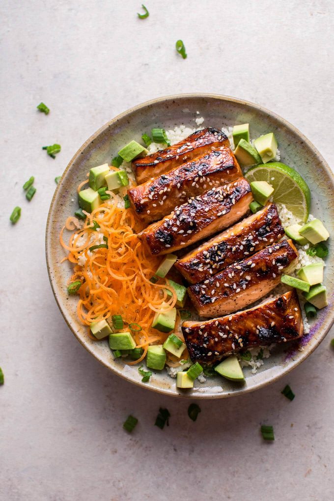 bowl of low-carb hoisin sesame salmon with avocado on a bed of cauliflower rice