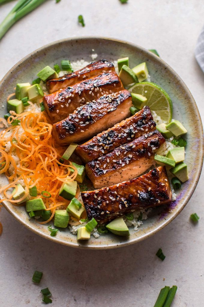 glazed hoisin and sesame salmon bowl in a bowl with avocado and cauliflower rice