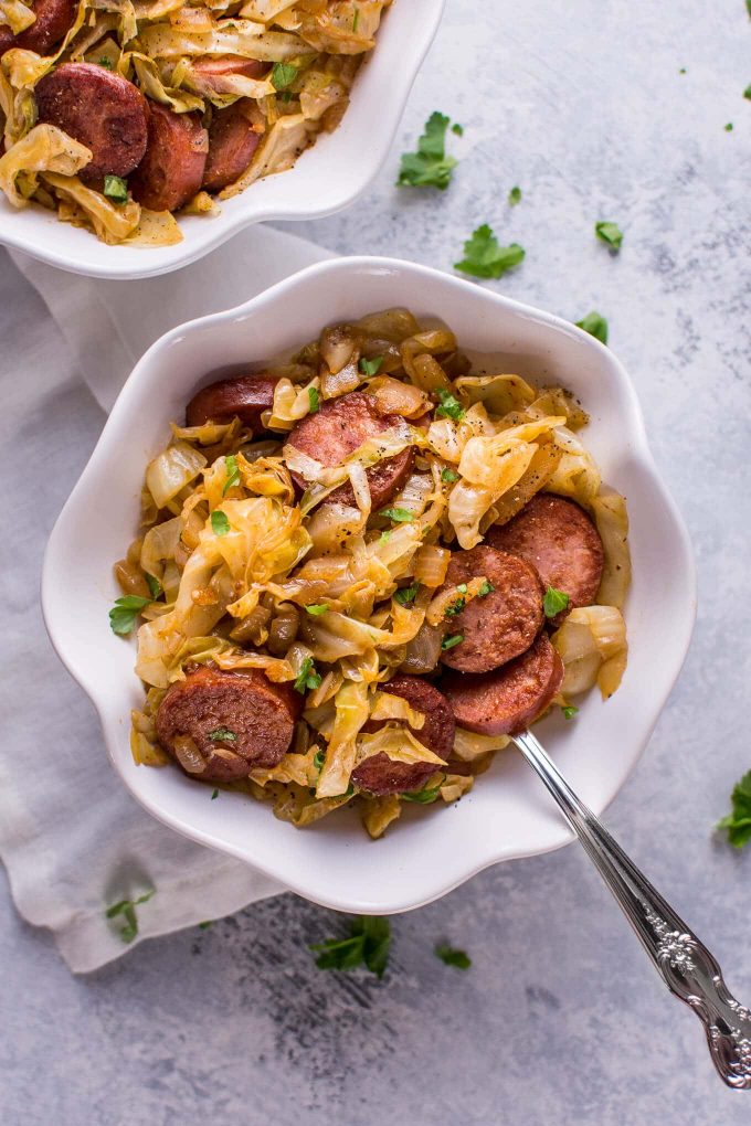 close-up of sauteed cabbage and kielbasa in a bowl with a fork