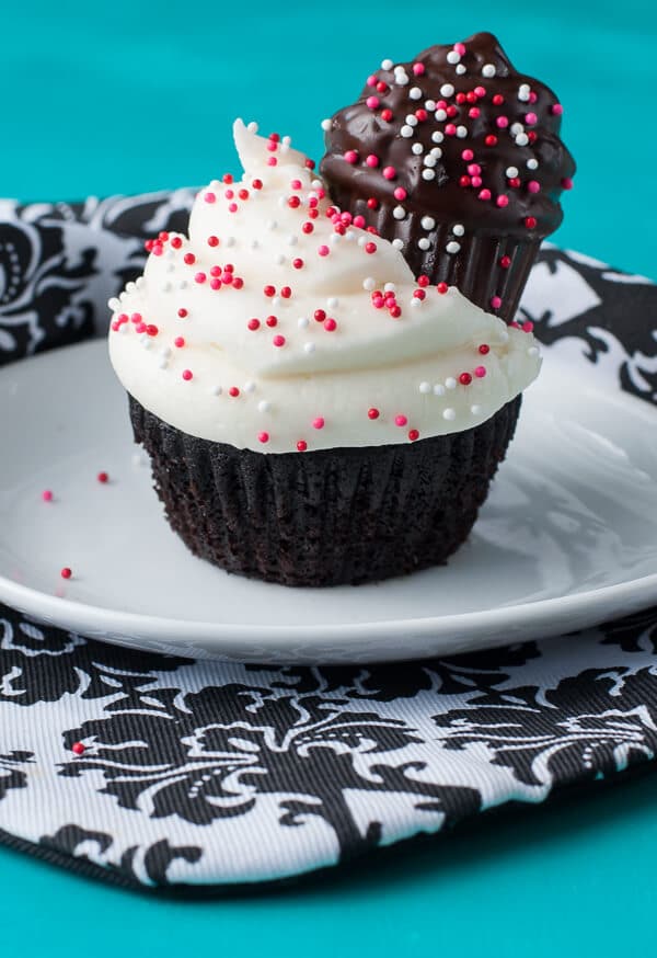 two small batch cupcakes on a plate with red and white sprinkles