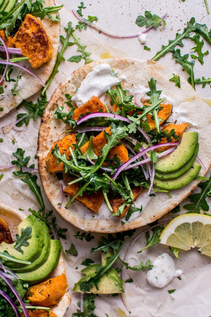 close-up of a sweet potato pita with arugula and avocado