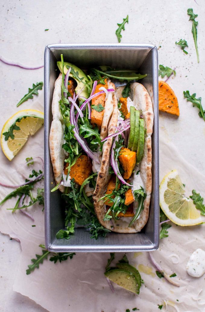metal container with two roasted sweet potato pitas and lemon slices