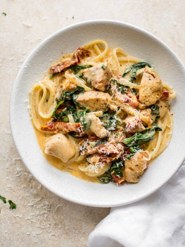 This creamy Tuscan chicken pasta recipe is even better than the Olive Garden's! You can quickly make this easy chicken, spinach, and sun-dried tomato pasta with a creamy garlic sauce at home in under half an hour!