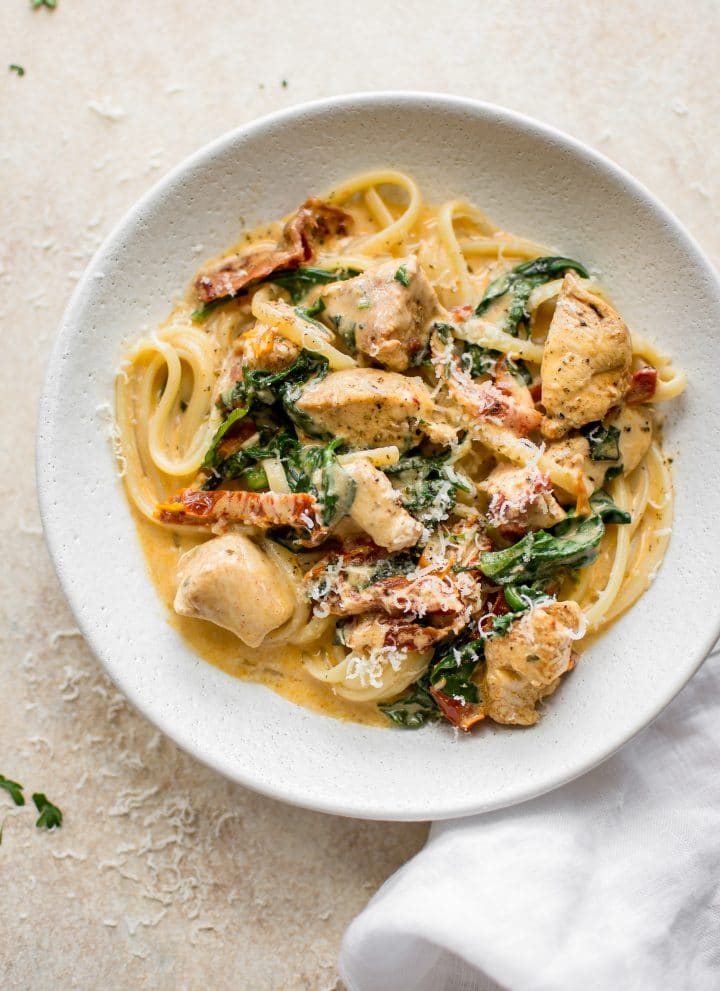 This creamy Tuscan chicken pasta recipe is even better than the Olive Garden's! You can quickly make this easy chicken, spinach, and sun-dried tomato pasta with a creamy garlic sauce at home in under half an hour!