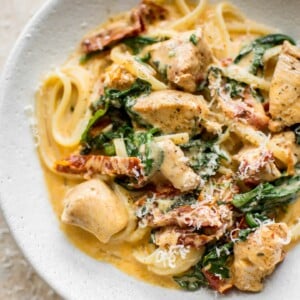 This creamy Tuscan chicken pasta recipe is even better than the Olive Garden's! You can quickly make this easy chicken, spinach, and sun-dried tomato pasta with a creamy garlic sauce at home in under half an hour!