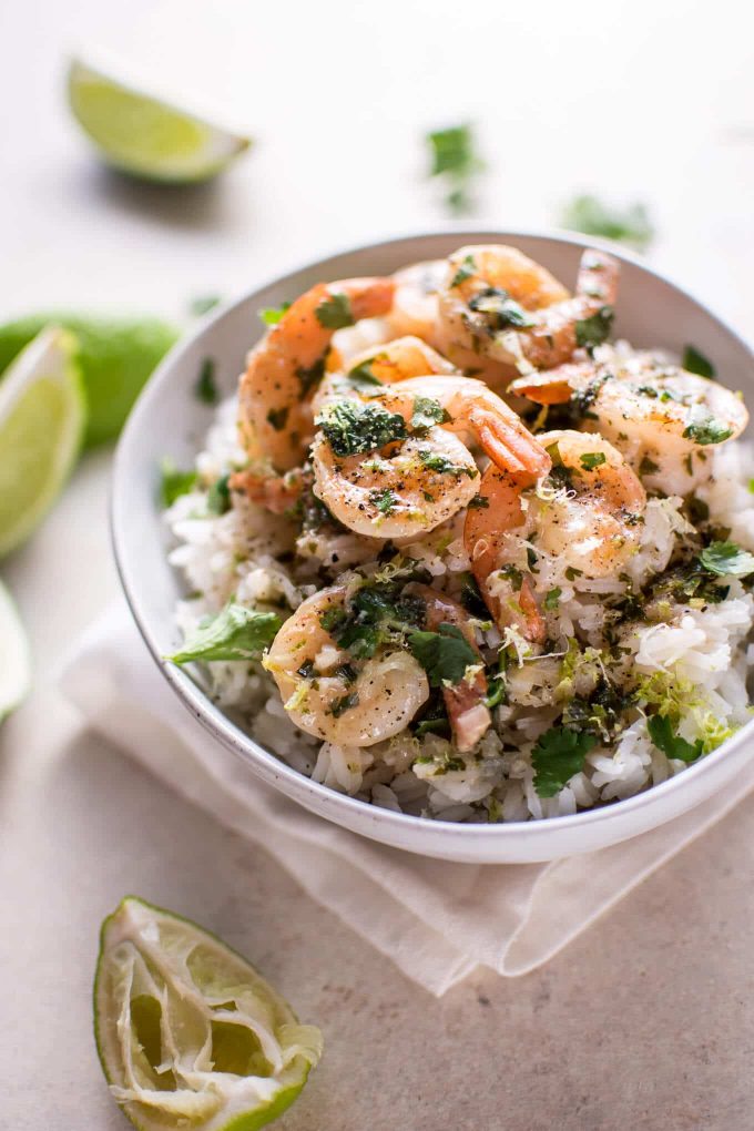 coconut lime shrimp in a white bowl with a lime wedge