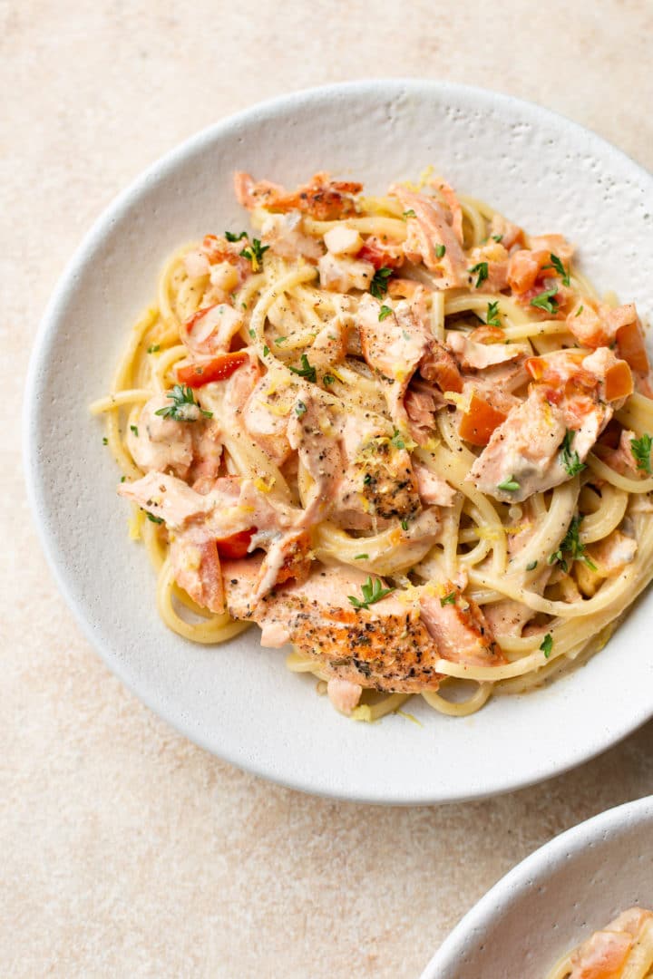 two white bowls of fresh tomato salmon pasta