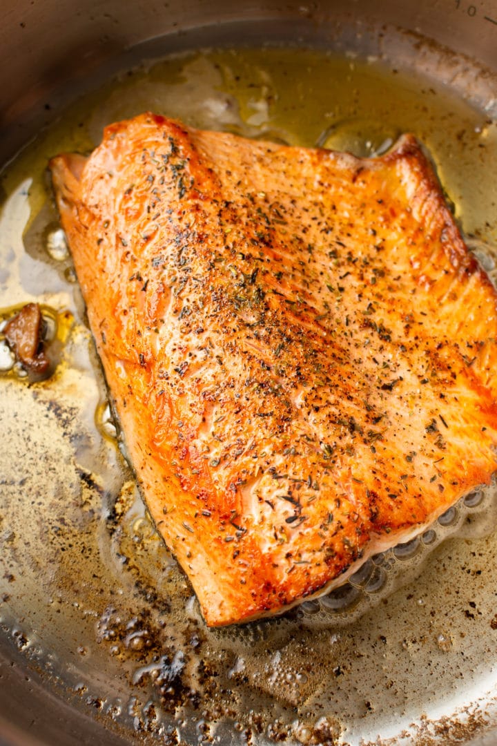 piece of fresh salmon searing in a skillet