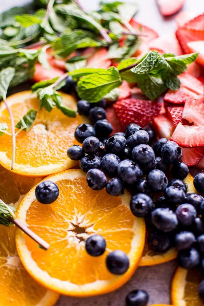 close-up of orange slices, strawberries, blueberries, and mint