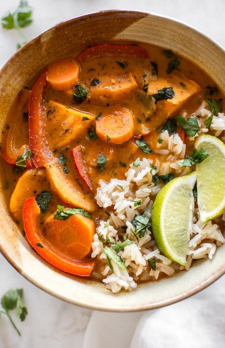 thai vegan coconut sweet potato curry in a bowl garnished with lime over rice