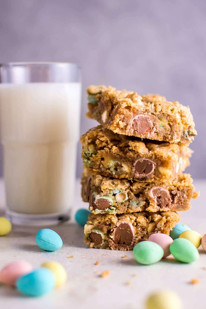 a stack of Mini Egg cookies with a glass of milk
