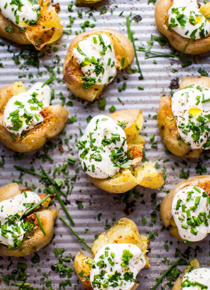 These garlic and lemon smashed potatoes are a fresh and flavorful side dish or party finger food. Replacing sour cream with Greek yogurt also makes these healthier!
