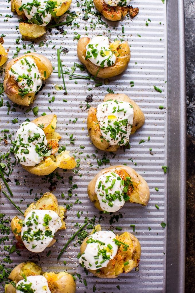 lemon and garlic smashed potatoes with Greek yogurt on a tray