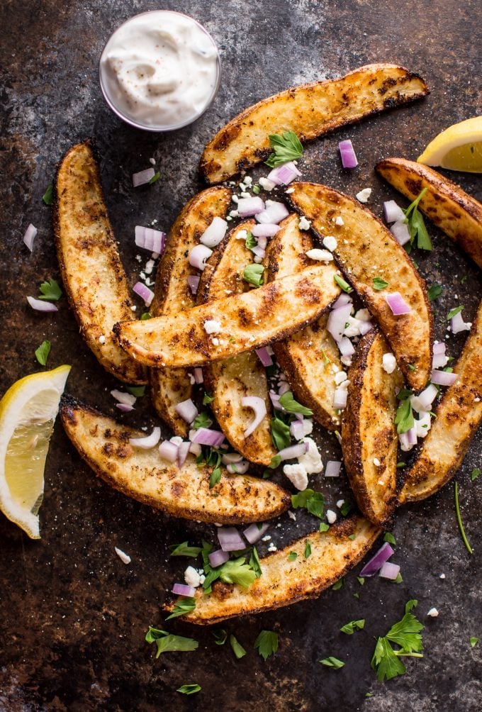 Greek loaded baked potato wedges with lemon wedges