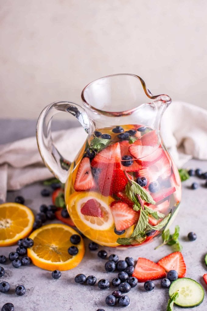 glass pitcher on a counter with rainbow infused water